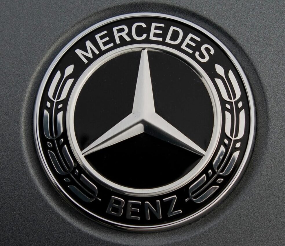 Detailed view of a luxury car logo on a sleek metallic surface.